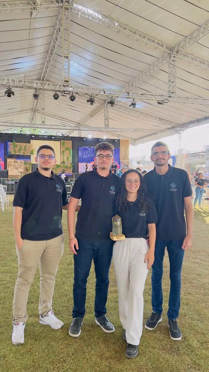 Quatro integrantes da Projetar com camisas da empresa, uma delas segura um troféu